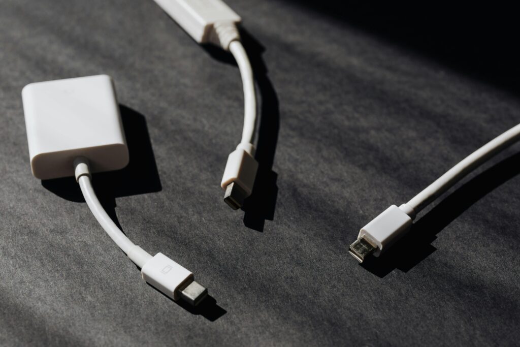 A collection of white USB and adapter cables on a textured dark background, perfect for tech themes.