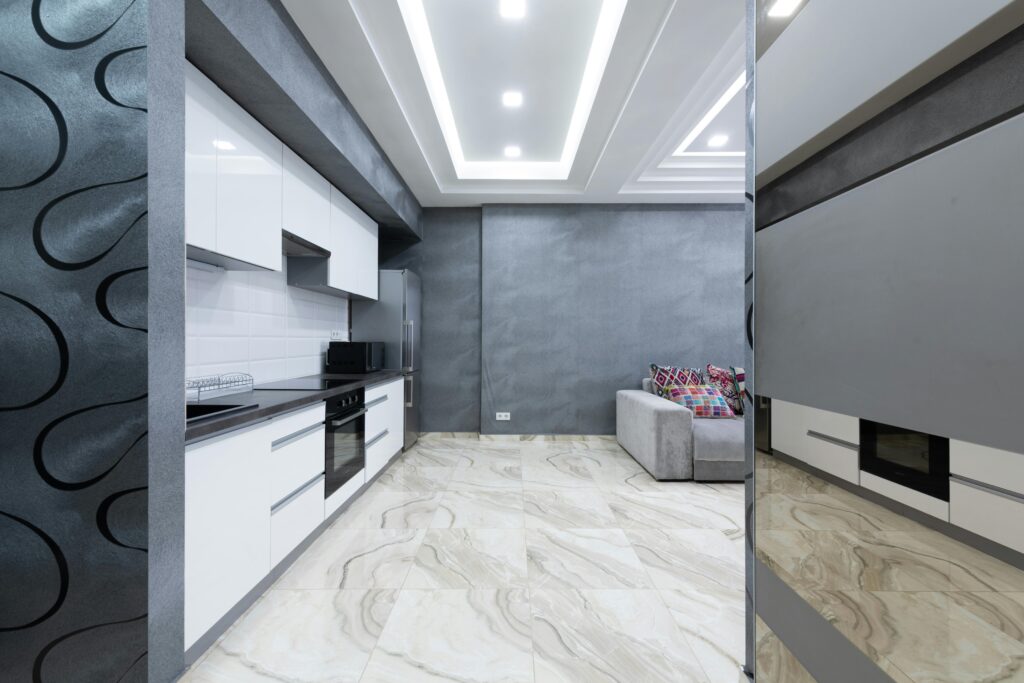Interior of stylish contemporary apartment with clean kitchen area with white cabinets and sofa